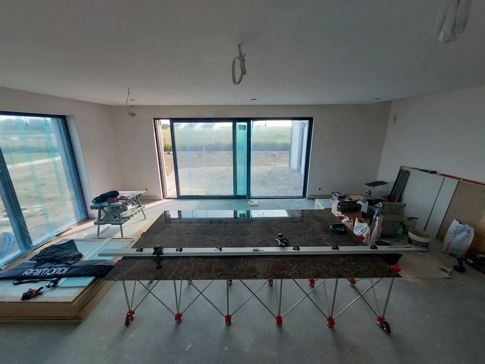 Układanie płytek wielkoformatowych na podporach w salonie z panoramicznymi oknami