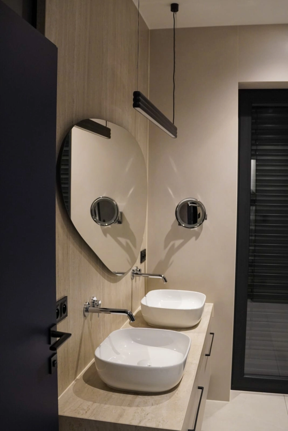 Dwie nowoczesne umywalki nablatowe z chromowaną armaturą ścienną i nieregularnym lustrem – Remont łazienki