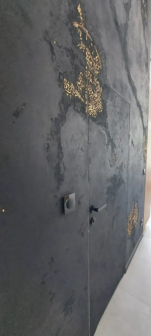 Drzwi wewnętrzne z czarną teksturą i złotymi ornamentami – montaż drzwi