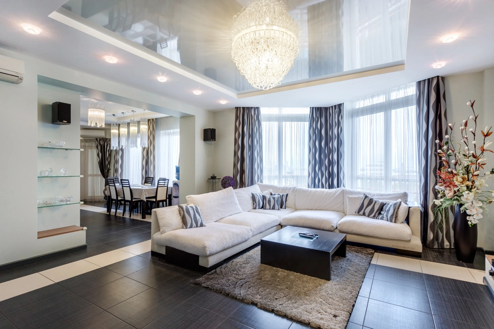 Przestronny salon z narożną kanapą, stolikiem kawowym i podłogą z płytek gresowych – układanie płytek